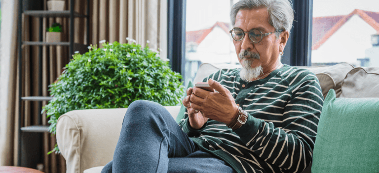 A man using his phone while sat on his sofa