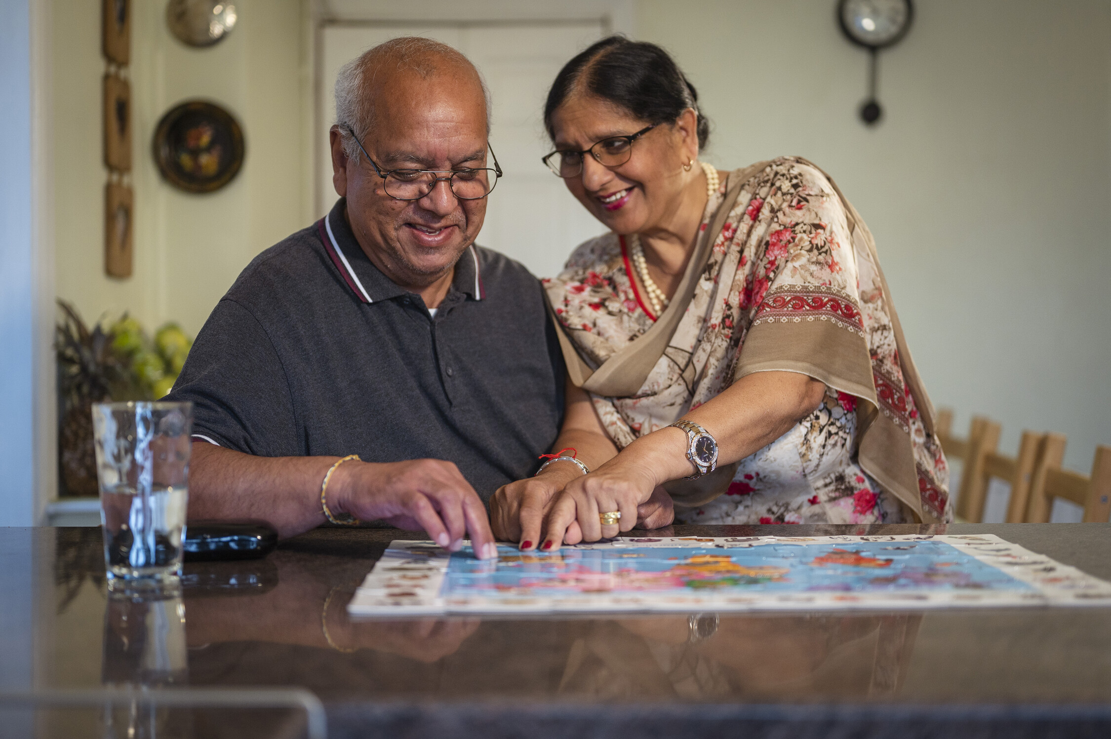 an older couple doing a jigsaw