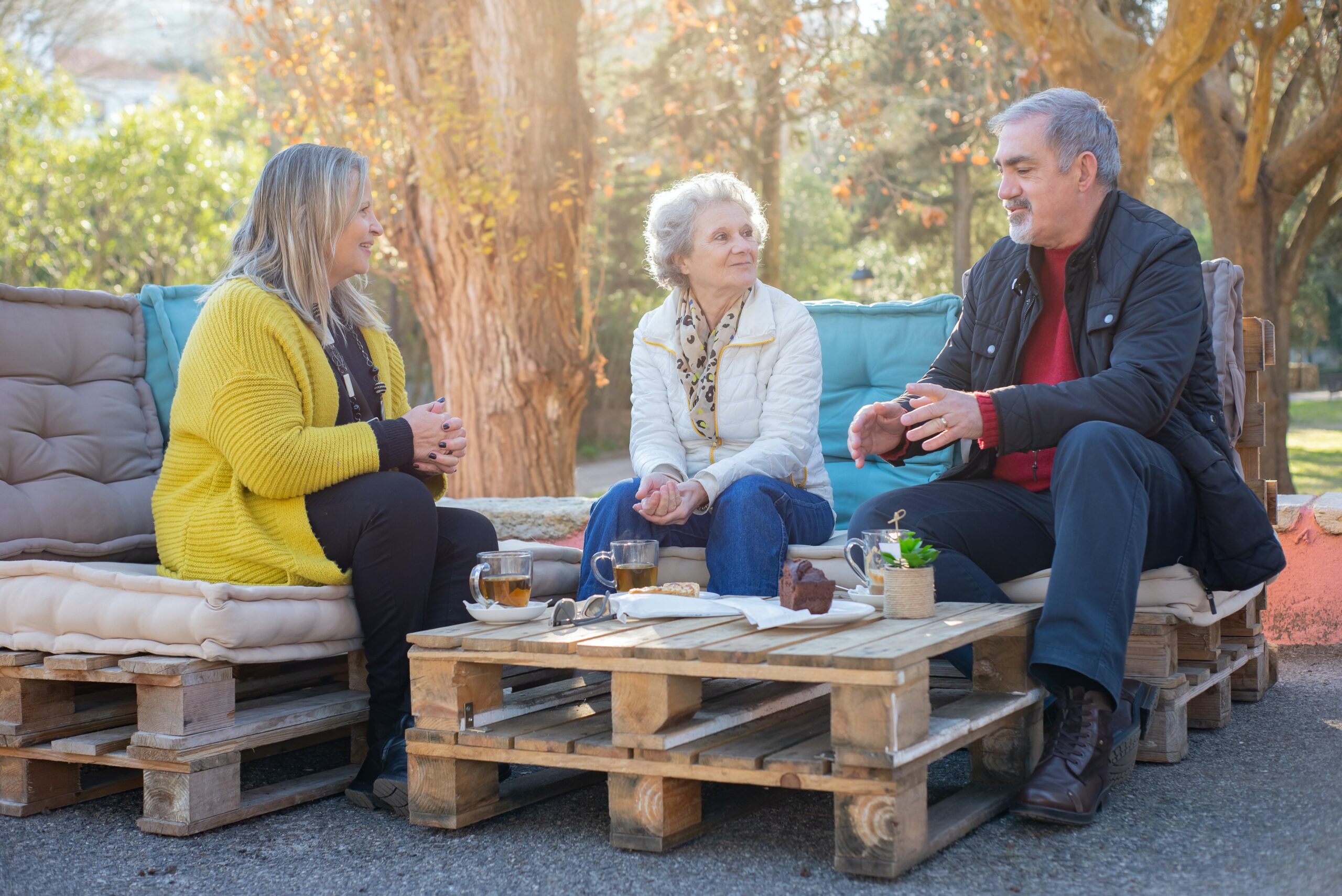 Three older people talking outside
