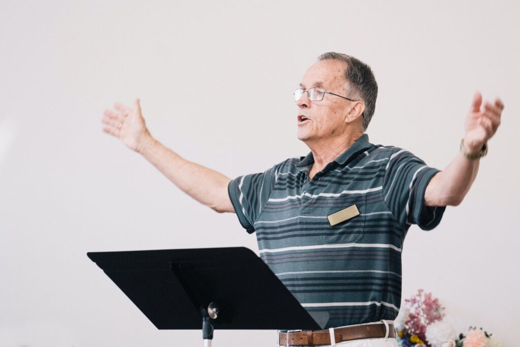 an older man guiding a choir session